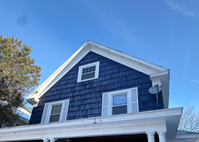 Residential home roof in winter showing snow buildup and shingle roofing system for seasonal maintenance