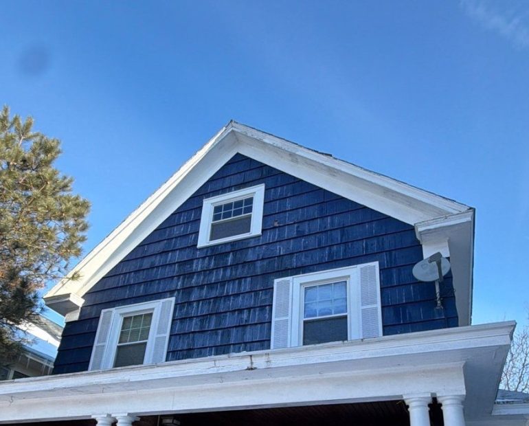Residential home roof in winter showing snow buildup and shingle roofing system for seasonal maintenance