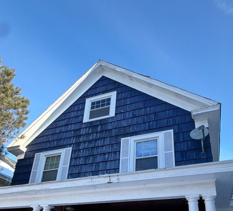 Residential home roof in winter showing snow buildup and shingle roofing system for seasonal maintenance