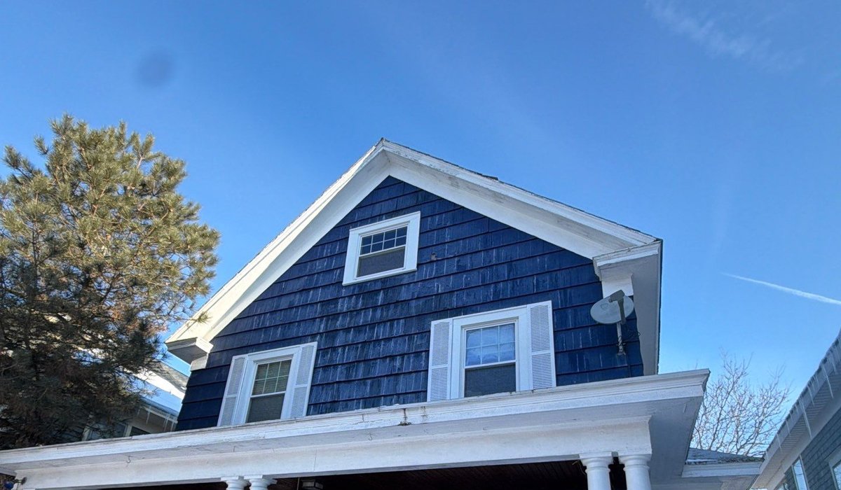 Residential home roof in winter showing snow buildup and shingle roofing system for seasonal maintenance