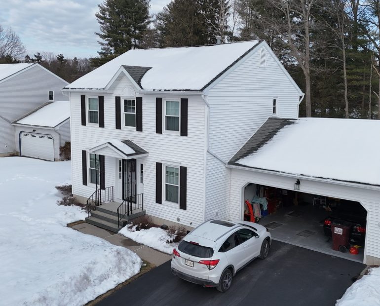 Residential house roof covered with snow showing roofing material performance in cold climate conditions
