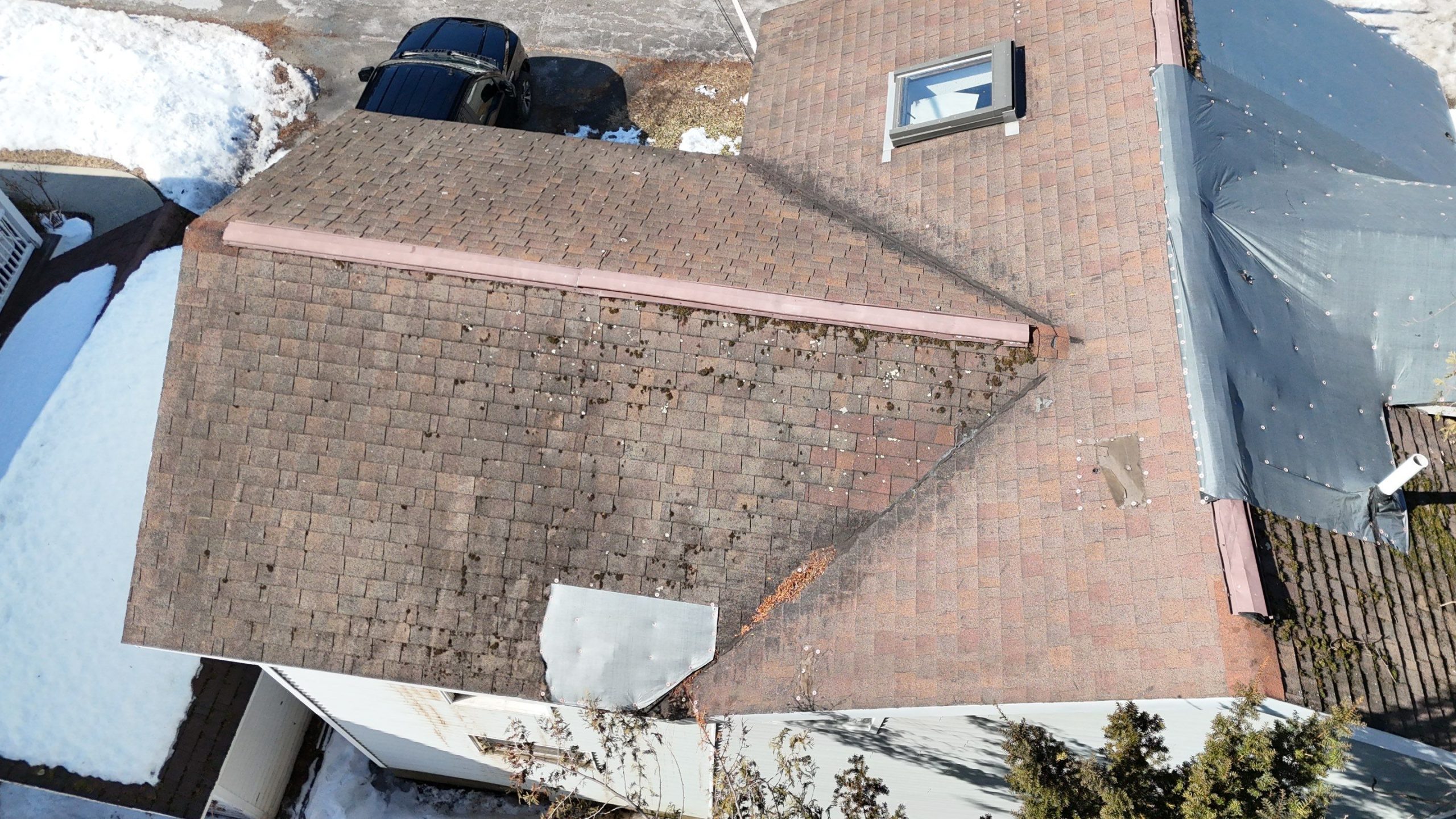 Damaged asphalt shingle roof with poor ventilation and moisture buildup affecting roof lifespan and increasing home energy bills
