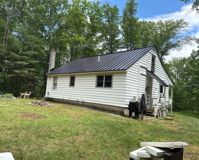 Modern black standing seam metal roof installed on a residential home