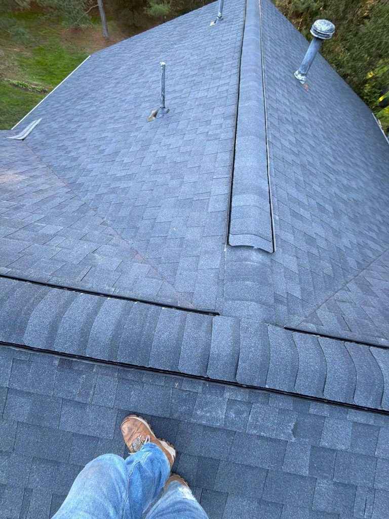 New asphalt shingle roof installation with synthetic underlayment on a residential home
