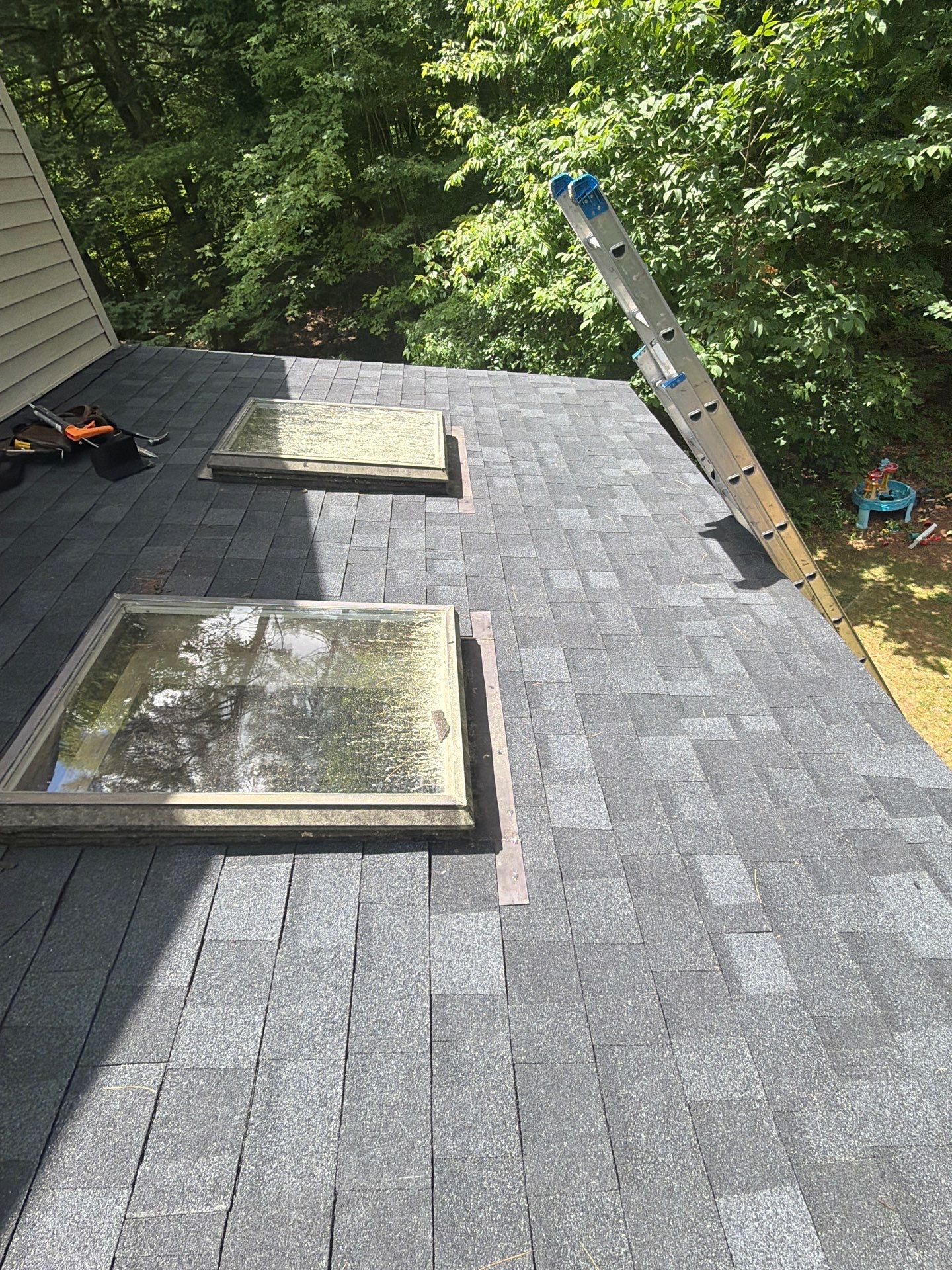 New asphalt shingle roof with replaced skylight flashing to improve waterproofing and prevent roof leaks.