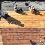 Plank roof decking exposed during roof replacement before new shingles are installed