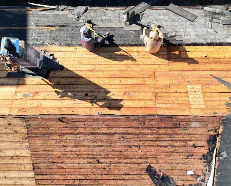 Plank roof decking exposed during roof replacement before new shingles are installed