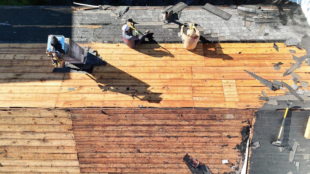 Plank roof decking exposed during roof replacement before new shingles are installed