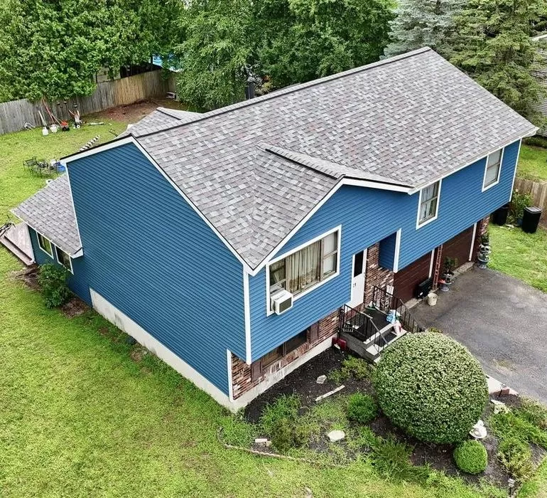 Top Roofing Materials Compared: Asphalt Shingles vs Metal vs Tile Top Roofing Materials Compared Asphalt Shingles vs Metal vs Tile Aerial view of a blue two-story residential house with asphalt shingle roofing and a driveway