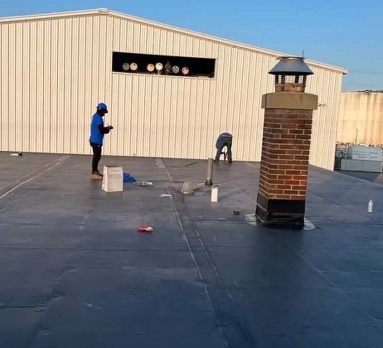 Roof Leak Repair: Common Causes, Warning Signs & Professional Solutions roof leak repair commercial flat roof Professional roof leak repair on commercial flat roof with technicians sealing membrane and flashing