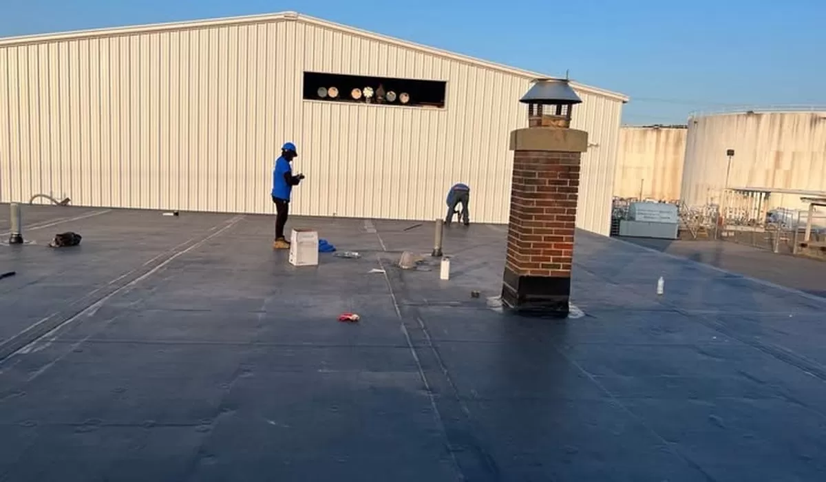 Roof Leak Repair: Common Causes, Warning Signs & Professional Solutions roof leak repair commercial flat roof Professional roof leak repair on commercial flat roof with technicians sealing membrane and flashing