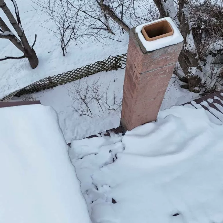 How Snow and Ice Can Damage Your Roof and Chimney how snow and ice damage roof chimney seo Snow and ice buildup around chimney causing roof and flashing damage during winter