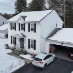 Residential house roof covered with snow showing roofing material performance in cold climate conditions