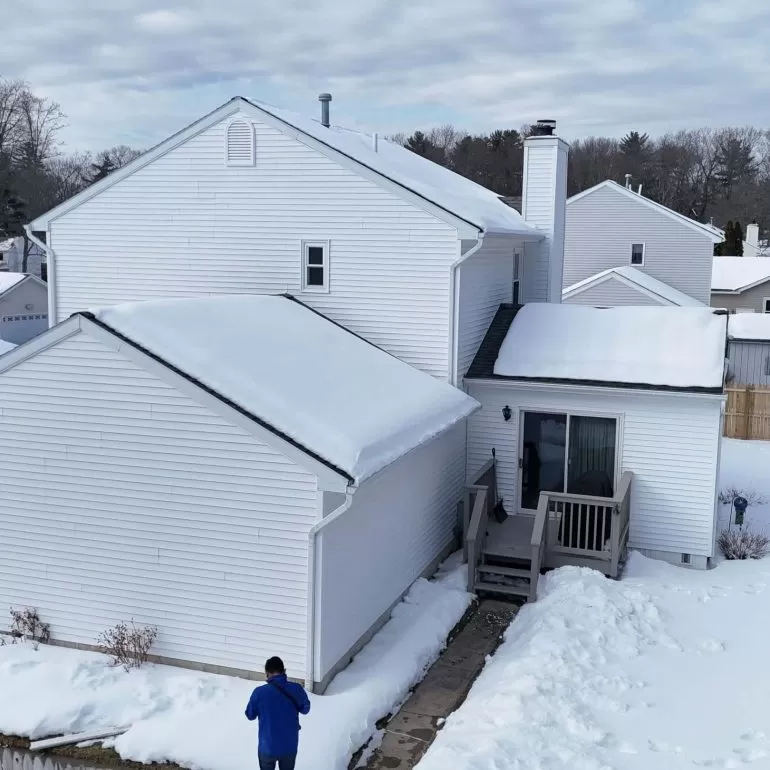 Metal Roofing Benefits: Why Many Homeowners Choose It in 2026 metal roofing benefits homeowners 2026 Snow covered residential home with sloped roof showcasing why homeowners choose durable metal roofing in 2026