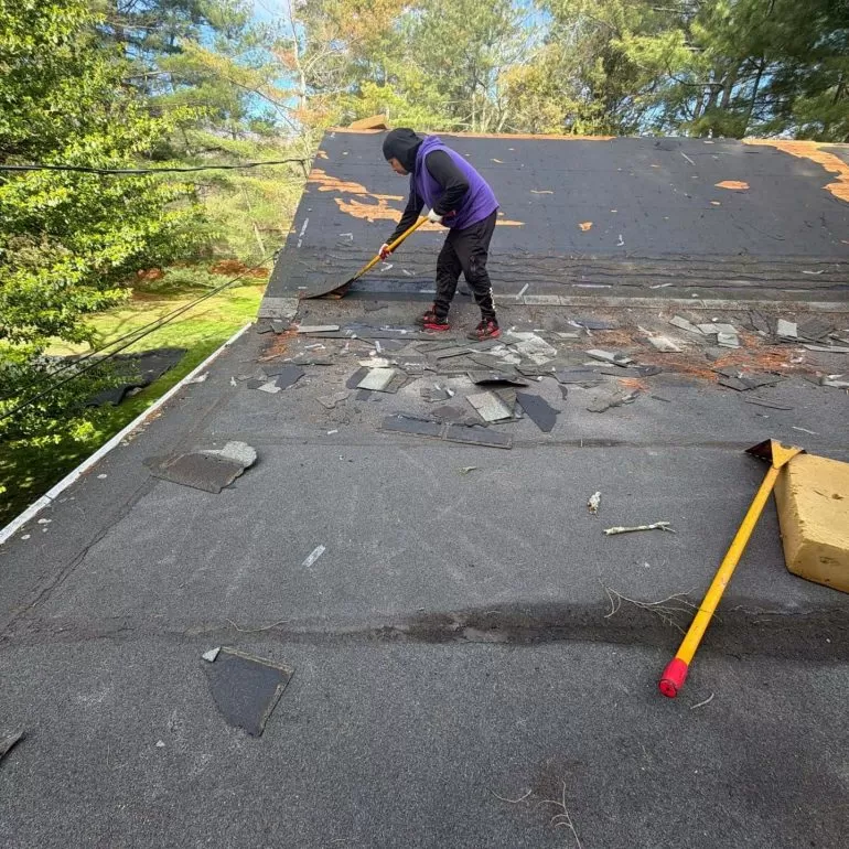 What to Expect During a Roof Replacement Project roof replacement project old shingle removal Worker removing old shingles during a residential roof replacement project to prepare for new roofing installation