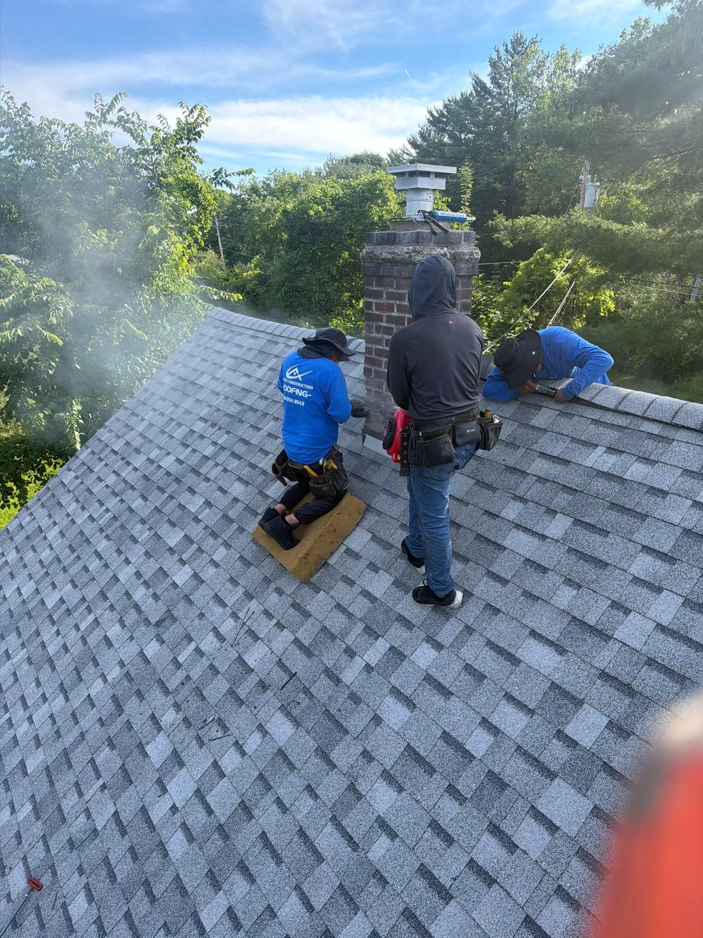 Chimney Flashing Repair for Asphalt Shingle Roofs chimney flashing repair asphalt shingle roof Roofing crew performing chimney flashing repair on an asphalt shingle roof during a residential roof replacement by Center Construction Roofing.