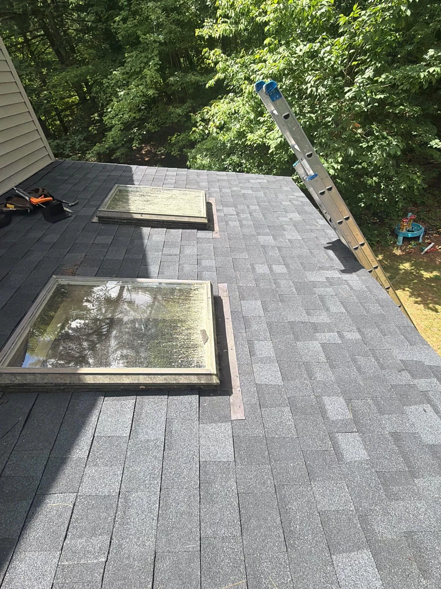 Skylight Roof Flashing Replacement: Protecting Your Roof from Leaks skylight roof flashing replacement New asphalt shingle roof with replaced skylight flashing to improve waterproofing and prevent roof leaks.
