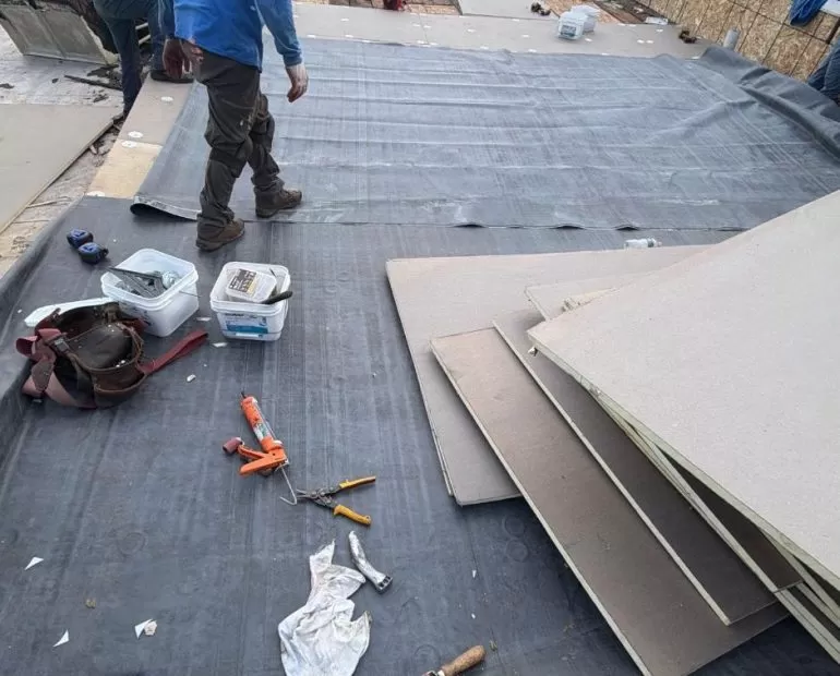 Commercial Flat Roof Membrane Preparation: Key Installation Steps commercial flat roof membrane preparation Commercial flat roof membrane preparation with workers installing roofing material over an exposed roof surface